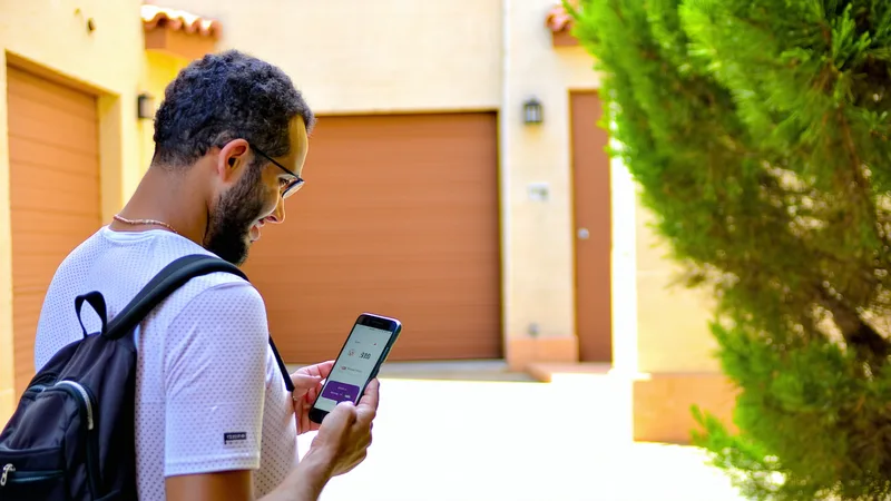 Propietario revisando ingresos en su teléfono junto a su garaje