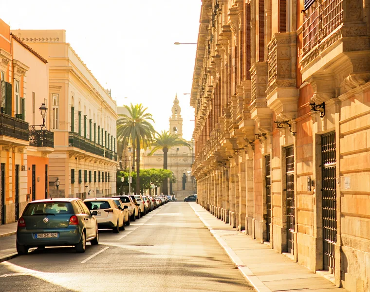 Calle con plazas de aparcamiento privadas en Valencia, luz mediterránea cálida